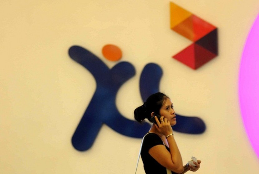 A woman passes in front of XL logo in Jakarta. (illustration)