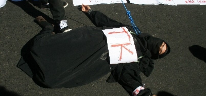 A woman plays dead in a protest that demands the government to put some restriction in sending Indonesian workers abroad. (photo file)  