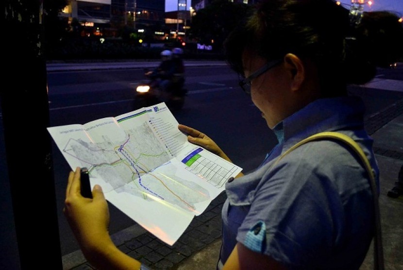 A woman reads map of the planned MRT lanes in Jakarta. 