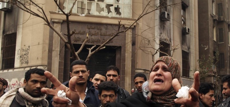 A woman shouts about the political situation in the country, in front of a damaged government building near the Interior Ministry in Cairo, Egypt, on Wednesday. 