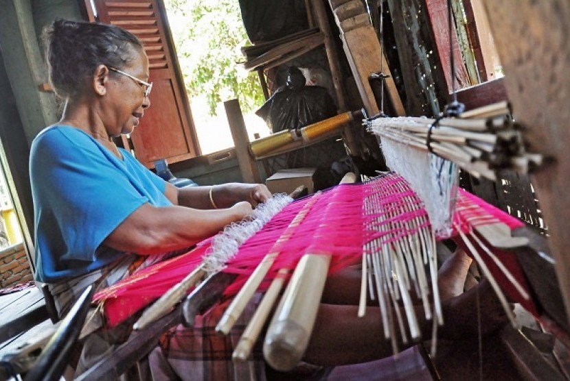 A woman weaves a piece of traditional woven fabric of West Nusa Tenggara. (illustration)      