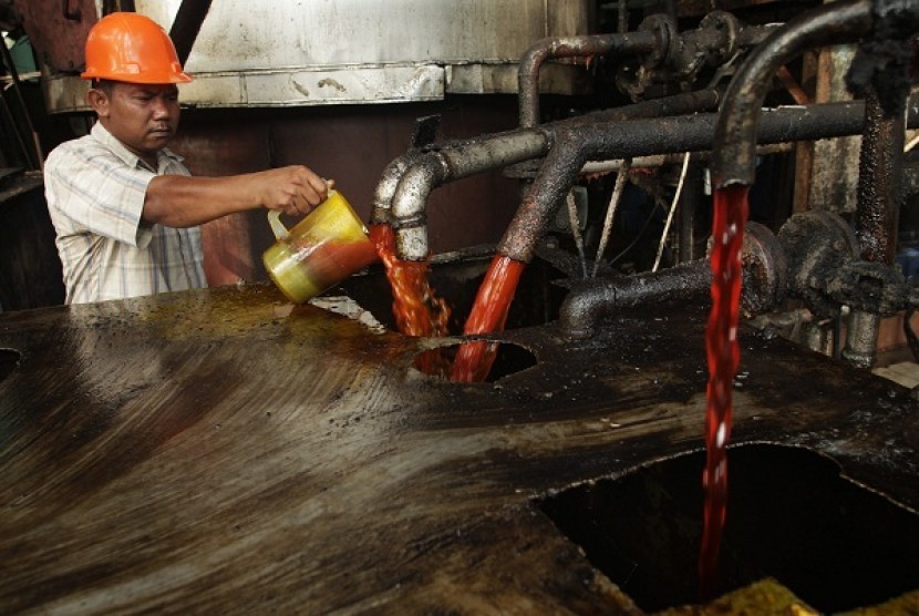 A worker checks the quality of crude palm oil (CPO). 