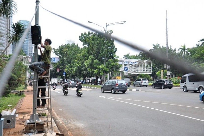 A worker fixes solar powered traffic sign in Jalan Sudirman, Jakarta. (illustration)
