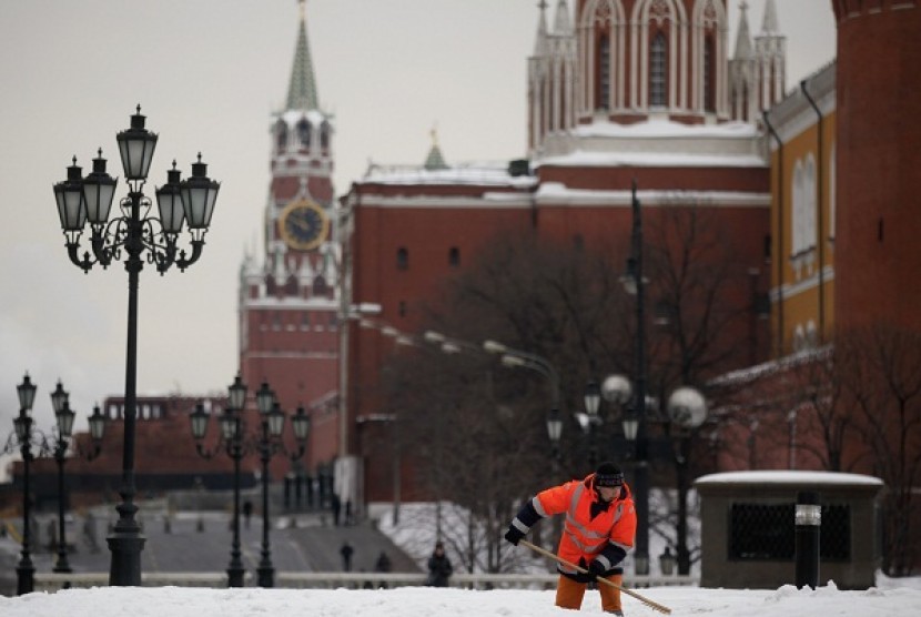 A worker shovels snow, with the Kremlin seen in the background, in central Moscow, Russia. (file photo)