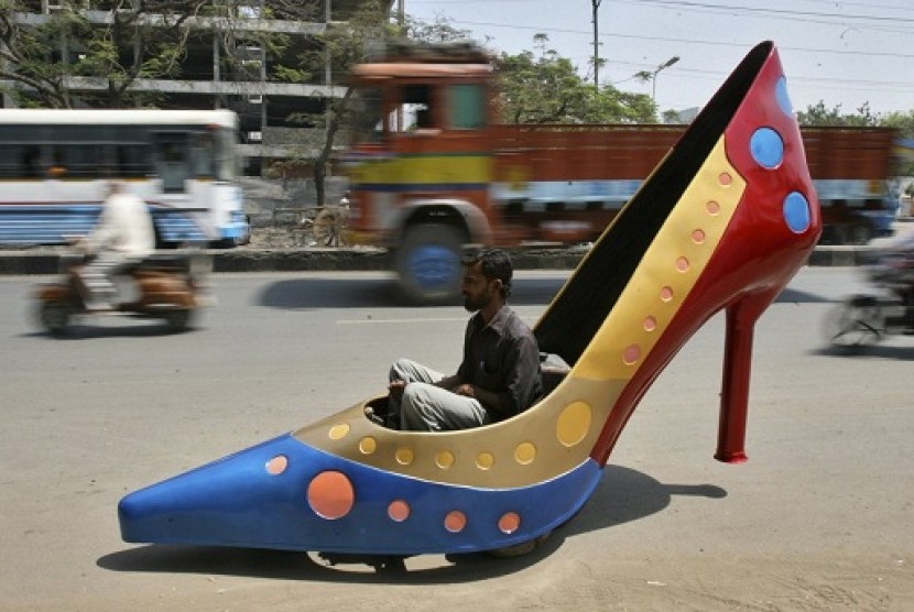 A worker test drives a car in the shape of a heels on a road in the southern Indian city of Hyderabad March 7, 2012. The shoe is part of a ladies series of creations by Indian car designer Sudhakar Yadav to mark the International Women's Day and the car ca