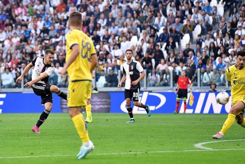 Aaron Ramsey (kiri) mencetak gol saat Juventus melawan Verona, Ahad (22/9) dini hari