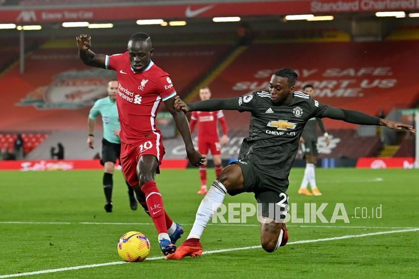  Aaron Wan-Bissaka dari Manchester United bersaing memperebutkan bola dengan Sadio Mane dari Liverpool, kiri, pada pertandingan sepak bola Liga Primer Inggris antara Liverpool dan Manchester United di Stadion Anfield, Liverpool, Inggris, Ahad (17/1).
