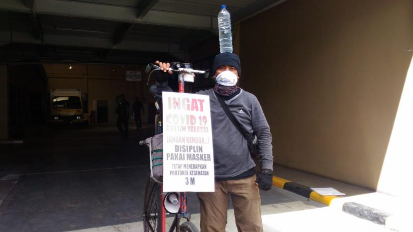 Abah Taufik yang akrab disapa lalakipeuting di kalangan pesepeda di Bandung melakukan gowes keliling Jabar menyosialisasikan protokol kesehatan 3M, Selasa (8/12). 