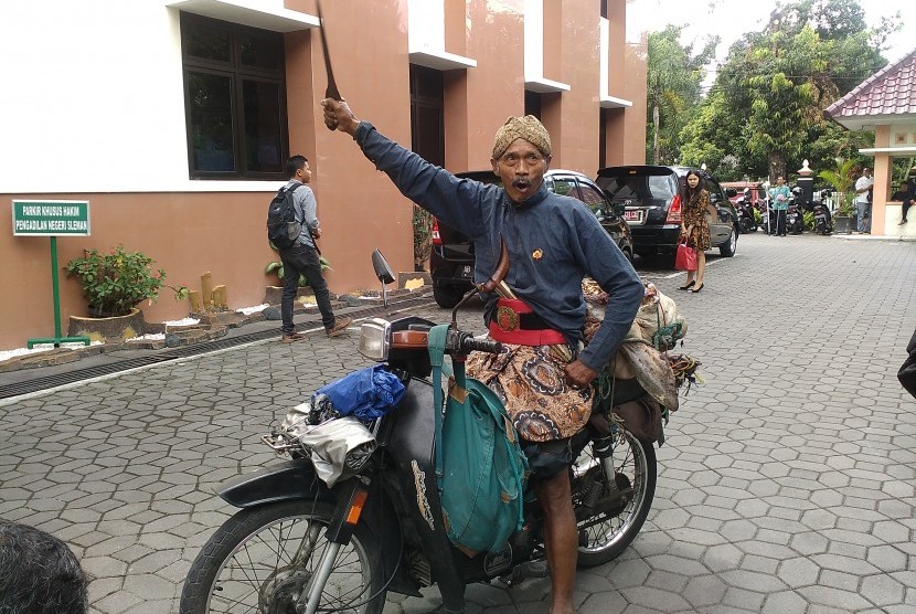 Abdi dalem Keraton Yogyakarta, Sudarsono, mengikat kepala sapi di belakang motor dan membawanya ke Pengadilan Negeri (PN) Sleman, Selasa (13/9).