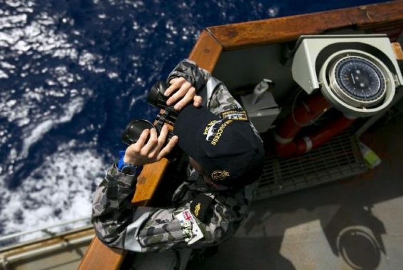 Able Seaman Boatswains Mate Marc Chandler looks through a pair of binoculars aboard the Australian Navy ship HMAS Success. as it continues to search for missing Malaysian Airlines flight MH370.