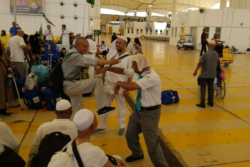Abu Yazan, kanan, seorang petugas Arab Saudi nampak mengajak 