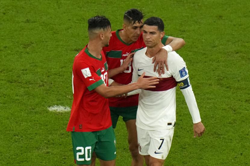  Achraf Dari Maroko (kiri) dan Jawad El Yamiq (tengah) menghibur Cristiano Ronaldo Portugal pada akhir pertandingan sepak bola perempat final Piala Dunia antara Maroko dan Portugal, di Stadion Al Thumama di Doha, Qatar,  Sabtu (10/12).