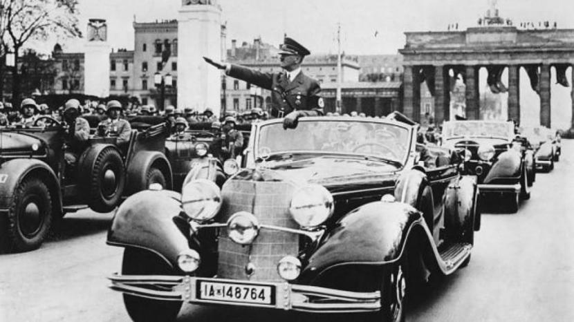 Adolf Hitler ketika menaiki limusin Mercedes Benz.
