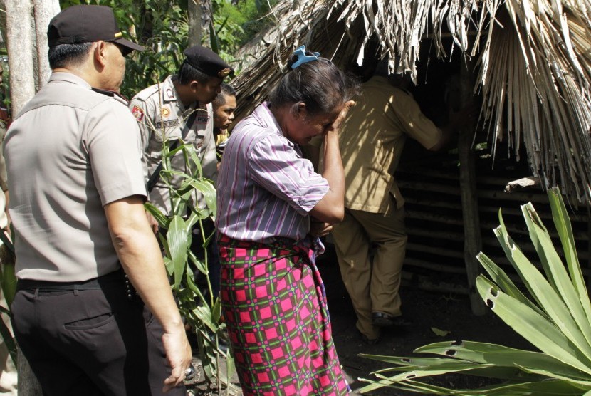 Adolfina Naonin (tengah) menangis ketika Bupati Kabupaten Kupang Ayu Titu Eki meninjau dirinya yang tinggal di kandang babi dengan seekor babi di desa Oebesi Kabupaten Kupang NTT Selasa (15/3). 