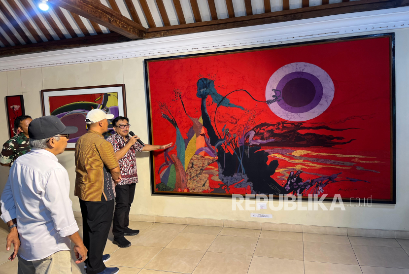 Adwi Prasetya Yogananta (kanan) menjelaskan mengenai salah satu lukisan sang ayah, Amri Yahya, dalam acara budaya Babad Siti Kemantren #3 yang mengangkat tema Metoda: Mengenal tokoh Legenda di Museum & Art Gallery Amri Yahya, Pakuncen, Wirobrajan, Yogyakarta, Ahad (31/8/2025).