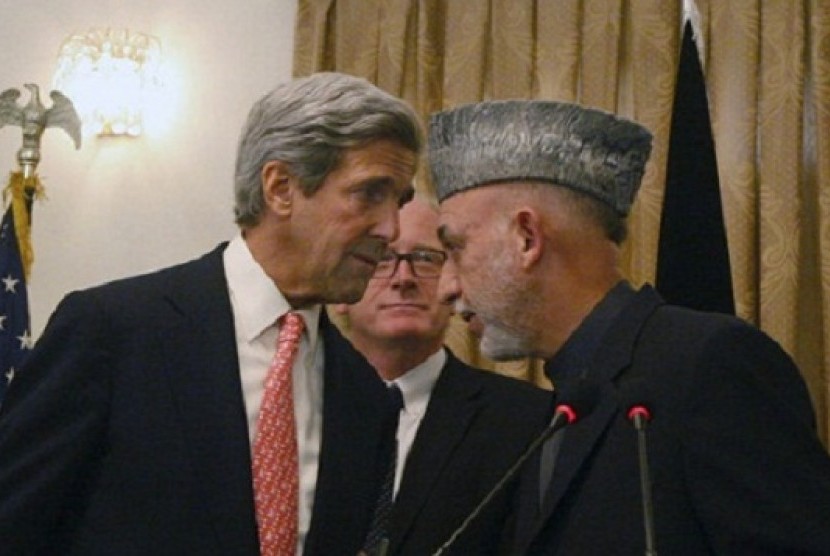 Afghan President Hamid Karzai, right, whispers with the US Sen. John Kerry, D-Mass, left,  in Kabul, Afghanistan on Tuesday, Oct. 20, 2009. (file photo)  