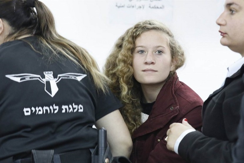 Ahed Tamimi dipeluk sanak saudaranya saat kedatangannya di Tepi Barat dekat Ramallah, Ahad (29/7). Tamimi dan ibunya dibebaskan tentara Israel setelah menjalankan delapan bulan penjara.