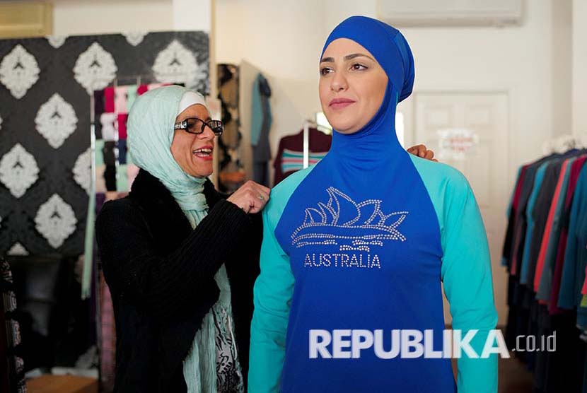 Aheda Zanetti (L), designer of the Burkini swimsuit, adjusts one of the swimsuits on model Salwa Elrashid at her fashion store in Sydney, August 23, 2016.   REUTERS/Jason Reed