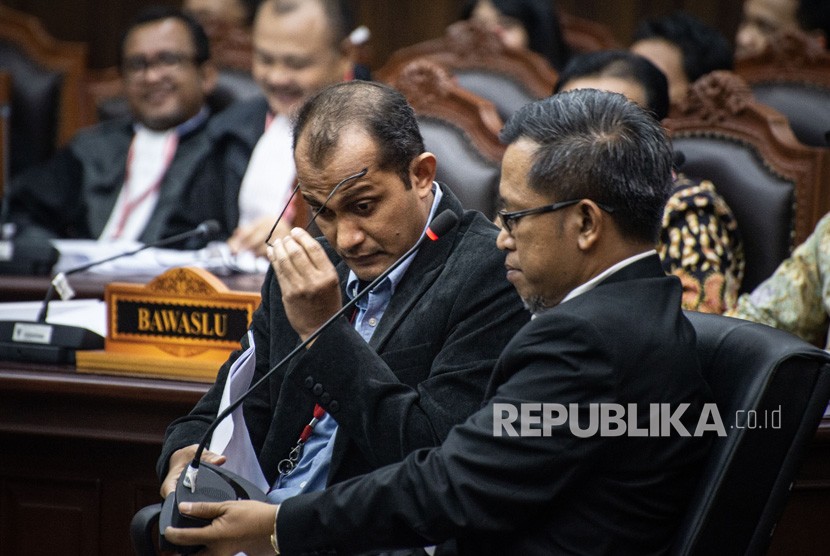 Ahli dari pihak terkait Prof Edward Omar Syarief Hiariej (kiri) dan Dr Heru Widodo (kanan) bersiap memberikan keterangan dalam sidang Perselisihan Hasil Pemilihan Umum (PHPU) presiden dan wakil presiden di Gedung Mahkamah Konstitusi, Jakarta, Jumat (21/6/2019). 