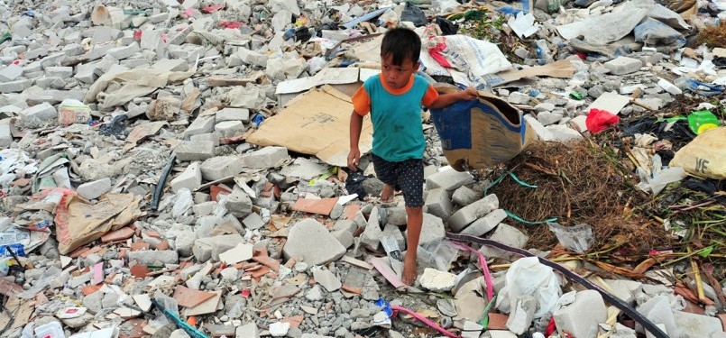 Ahmad (6), mencari sampah plastik diantara tumpukan sampah dan limbah bekas pembangunan proyek di kawasan Muara Angke, Jakarta Utara, Selasa (31/1). (Republika/Edwin Dwi Putranto)