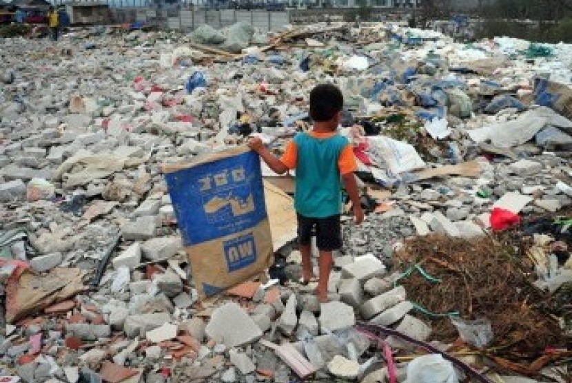 Ahmad (6), mencari sampah plastik diantara tumpukan sampah dan limbah bekas pembangunan proyek di kawasan Muara Angke, Jakarta Utara, Selasa (31/1). (Republika/Edwin Dwi Putranto)