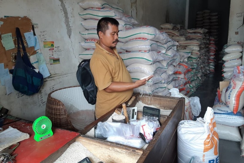 Ahmad Fauzi (38 tahun) pedagang beras di Pasar Leuwi Panjang, Purwakarta, sedang menunjukan beras kualitas medium yang sampai saat ini harganya masih stabil, Selasa (30/10).