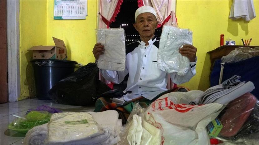 Ahmad Mahmudi, calon jemaah haji asal Purbalingga, Jawa Tengah yang gagal berangkat tahun ini menunjukkan perlengkapan ibadah haji yang dia terima dari pemerintah. 