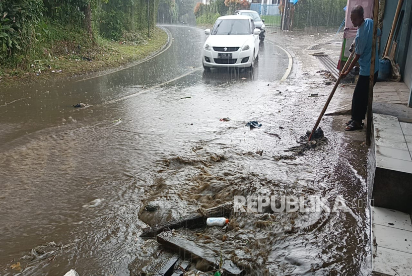 Air Bercampur Kotoran Sapi Meluap dari Drainase Hingga Menggenangi Jalan Kolonel Masturi di Desa Cikahuripan, Kecamatan Lembang, Kabupaten Bandung Barat.