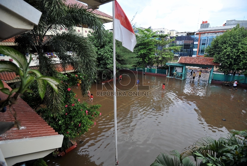 Air menggenangi halaman SD 4 Penjaringan, Jakarta Utara, Selasa (10/2). Aktifitas belajar mengajar di sekolah itu terpaksa dihentikan karena terendam banjir serta sebagian ruang kelas digunakan untuk mengungsi. 