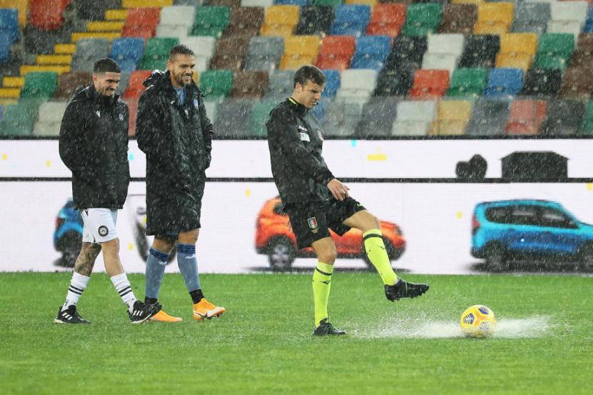  air menggenangi lapangan Stadion Friuli, Udine, Ahad (6/12). 
