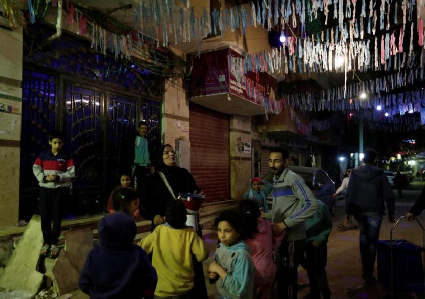 Hajja Dalal, seorang Mesaharati berusia 46 tahun, menabuh genderang untuk membangunkan umat Islam untuk makan subuh sebelum mereka memulai puasa hari panjang mereka selama Ramadan, di lingkungan Maadi di Kairo, Mesir.