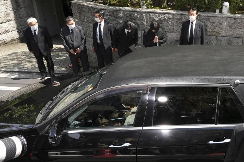  Akie Abe, di dalam mobil, istri mantan Perdana Menteri Jepang Shinzo Abe, duduk di mobil jenazah yang diyakini membawa jenazah Abe, tiba di rumahnya sebagai Ketua Dewan Riset Kebijakan Partai Demokrat Liberal Sanae Takaichi, kedua dari kanan , berdoa Sabtu, 9 Juli 2022, di Tokyo. 