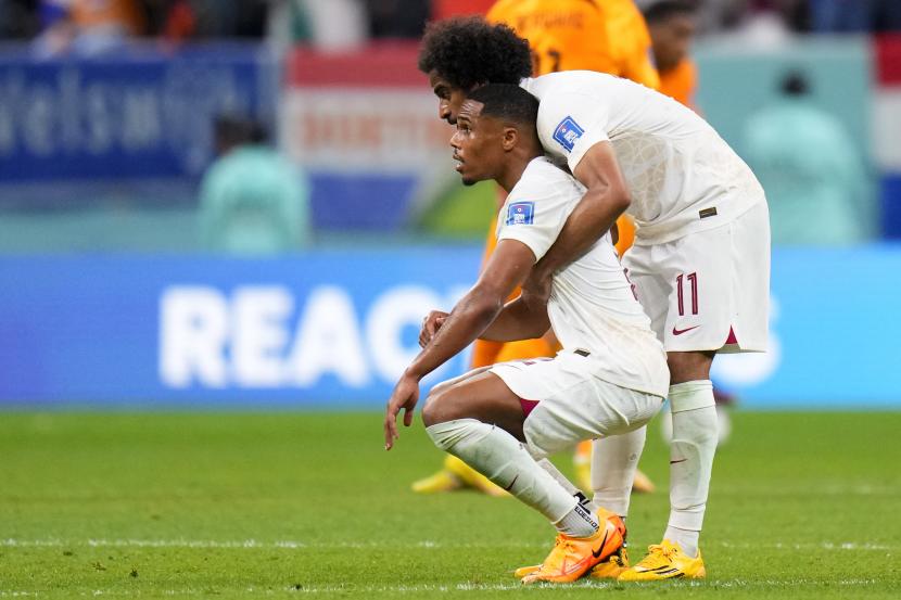 Akram Afif dari Qatar merangkul rekan setimnya di akhir kekalahan 0-2 mereka melawan Belanda selama pertandingan sepak bola grup A Piala Dunia di Stadion Al Bayt di Al Khor, Qatar, Selasa, 29 November 2022. 