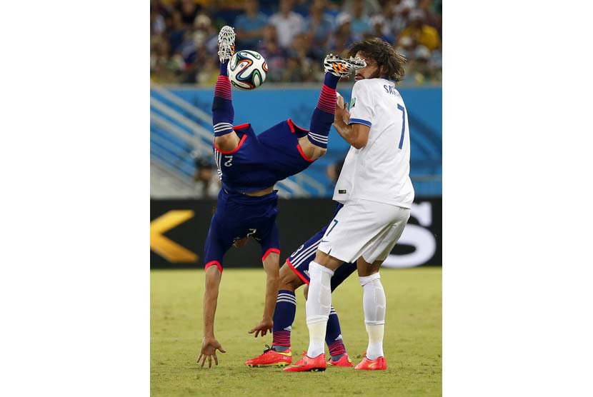 Aksi Atsuto Uchida (kiri) dari Jepang kepada Georgios Samaras (kanan) dari Yunani dipertandingan babak penyisihan antara Jepang dan Yunani di Estadio Arena das Dunas di Natal, Brasil,  Kamis (19/6).  (EPA/Kamil Krzacznyski).