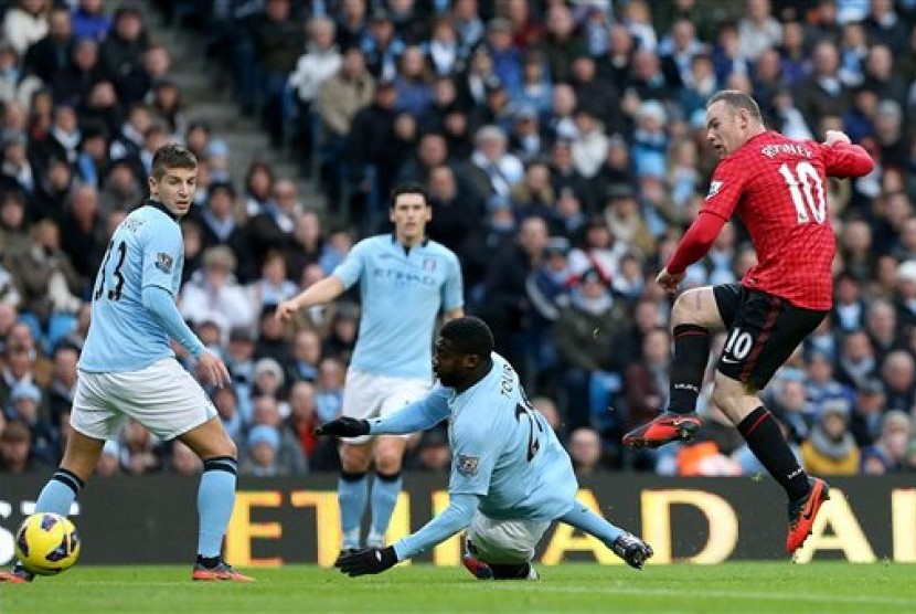 Aksi bomber Manchester United, Wayne Rooney, saat membobol gawang Manchester City pada laga Liga Primer di Etihad Stadium, Ahad (9/12) malam.