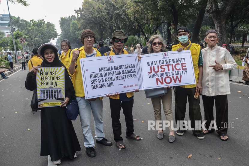 Aksi di Sekitar Gedung MK. Sejumlah massa aksi membentangkan poster di Jalan Merdeka Barat, Jakarta Pusat, Jum’at (14/6). 