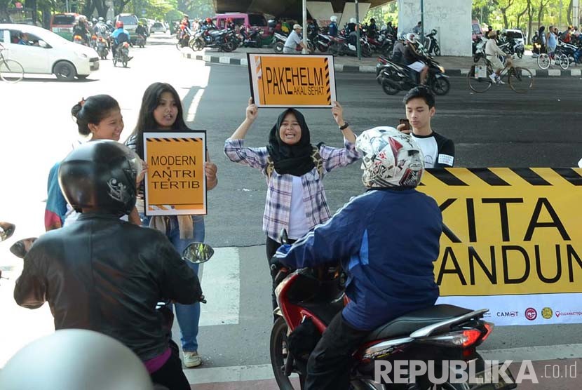 Aksi Gerakan Bandung Disiplin oleh para relawan di lampu merah di perempatan Taman Dago Cikapayang, Kota Bandung, Ahad (13/3).