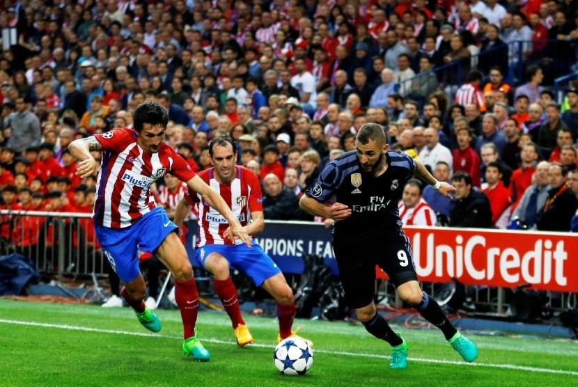 Aksi Karim Benzema (kanan) melewati para pemain Atletico Madrid.