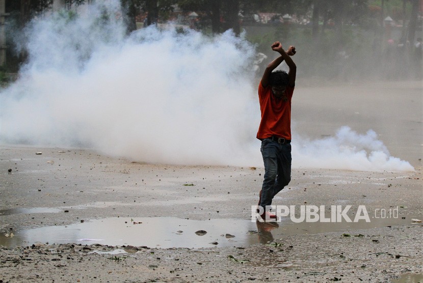  Aksi Mahasiswa Berakhir Bentrok. Mahasiswa bertahan di antara kepulan asap gas air mata yang dilontarkan oleh aparat kepolisian Polda Sultra yang melakukan pengamanan di depan pintu gerbang kantor Gubernur Sulawesi Tenggara saat aksi unjuk rasa meminta Pemerintah Provinsi Sulawesi Tenggara mencabut semua IUP Pertambangan di Konawe Kepulauan, Kendari, Sulawesi Tenggara, Senin (11/3/2019).