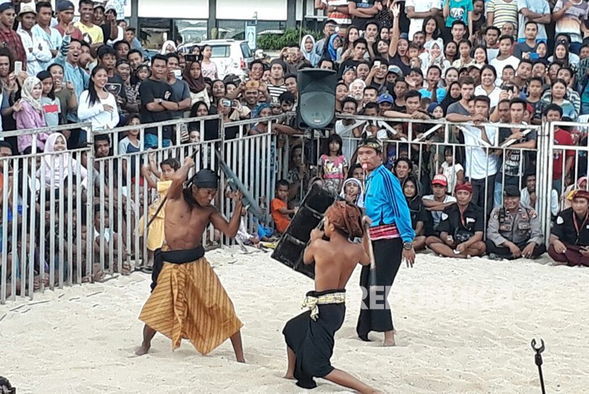 Aksi Peresean atau pertarungan antara dua lelaki yang bersenjatakan tongkat rotan dan berperisai kulit kerbau yang tebal dan keras di Pantai Kuta Mandalika, Lombok Tengah, Kamis (1/3).