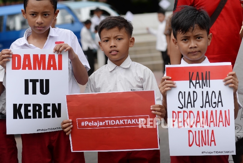 Aksi simpatik #kamitidaktakut digelar sejumlah siswa siswa SD sampai SMA di depan pos polisi bunderan HI, Jakarta Pusat, Jumat (15/1). ( Republika/ Yasin Habibi )