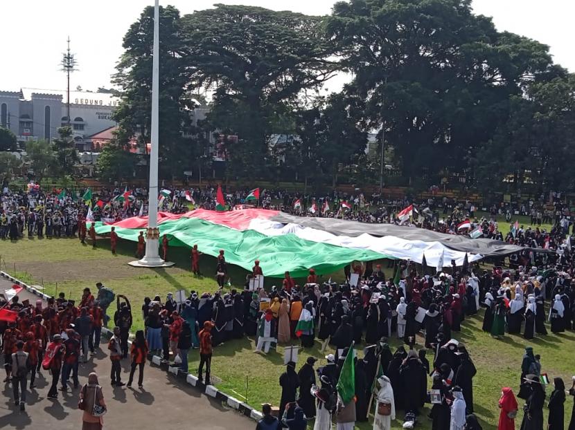 Aksi solidaritas warga Sukabumi membela Palestina dengan membentangkan bendera Palestina di Lapangan Merdeka, Ahad (23/5)