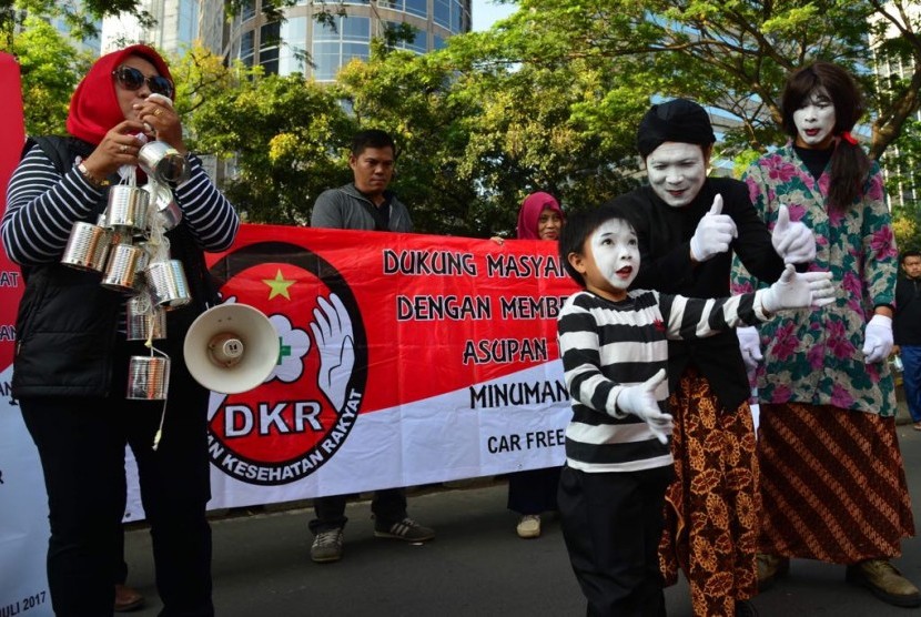 Aksi teatrikal tentang bahayanya minum susu kental manis oleh Dewan Kesehatan Rakyat (DKR) di hari bebas kendaraan Jalan MH THamrin, Jakarta, Ahad (30/7).