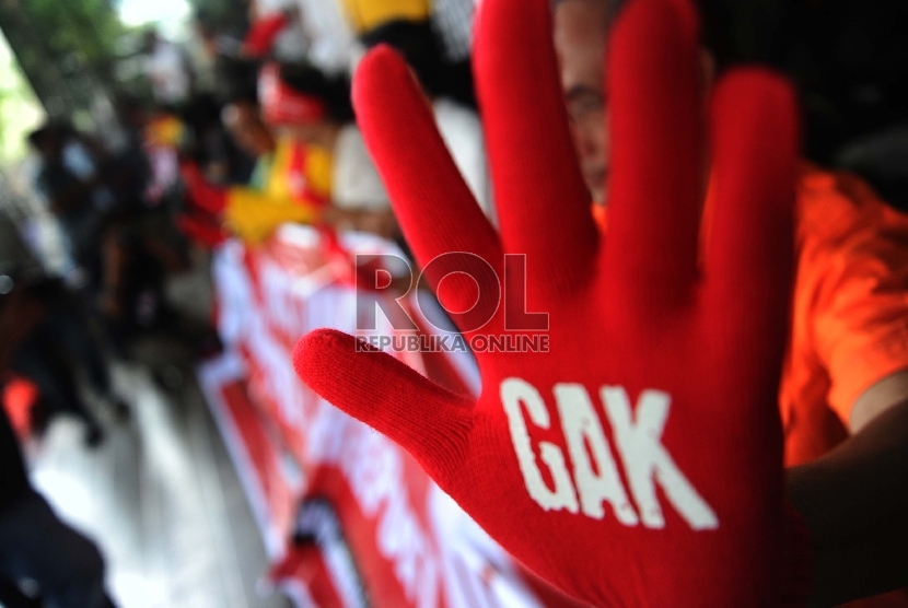 Aktifis dari Gerakan Anti Korupsi Alumni Lintas Perguruan Tinggi mengunakan sarung tangan saat aksi solidariatas di Gedung KPK, Jakarta, Jumat (27/11). (Republika/Tahta Aidilla)