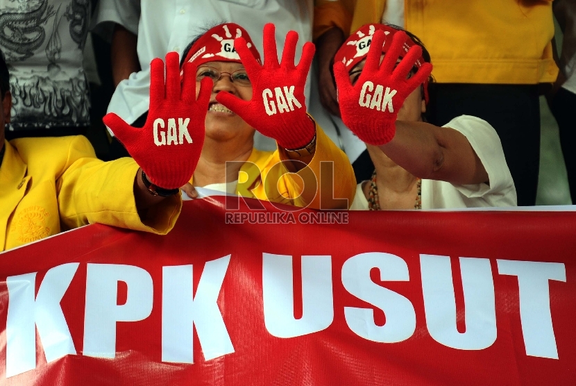 Aktifis dari Gerakan Anti Korupsi Alumni Lintas Perguruan Tinggi mengunakan sarung tangan saat aksi solidariatas di Gedung KPK, Jakarta, Jumat (27/11). (Republika/Tahta Aidilla)