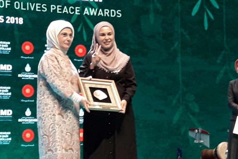 Aktivis dan relawan Muslimah Medical Emergency Rescue Committee (Mer-C) Nur Fitri Taher (kanan) menerima penghargaan dari International Mount of Olive Peace Awards yang diserahkan Ibu Negara Turki Emine Erdogan, Senin (7/5) di Istanbul, Turki.