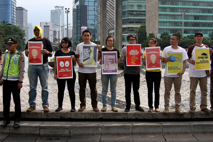 Aktivis dari KontraS memegang poster bertemakan HAM saat melakukan aksi di Bundaran HI, Jakarta, Kamis (10/12).