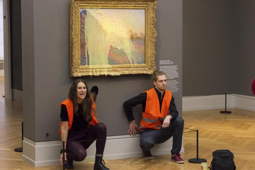 Aktivis iklim dari Last Generation duduk setelah melempar kentang tumbuk ke lukisan Claude Monet Les Meules di Museum Barberini Potsdam pada Ahad, 24 Oktober 2022, untuk memprotes ekstraksi bahan bakar fosil.
