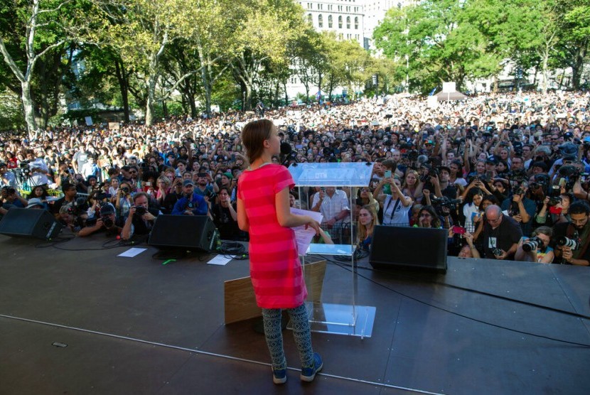 Aktivis iklim remaja dari Swedia Greta Thunberg (tengah) berbicara dalam Climate Strike, sebuah aksi agar pemimpin dunia melakukan tindakan lebih mengatasi perubahan iklim di New York, AS, Jumat (20/9). 