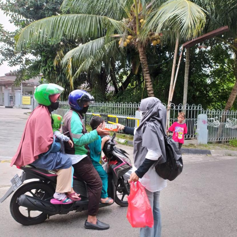 Aktivis Ikrar Depok membagikan takjil ke pengendara sepeda motor.
